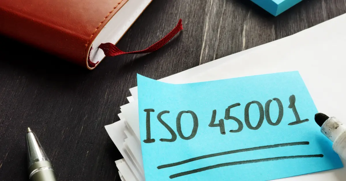 Notas sobre la implementación de ISO 45001 escritas con plumón negro en un papel sobre un escritorio, simbolizando los primeros pasos hacia la seguridad y salud ocupacional mejorada.